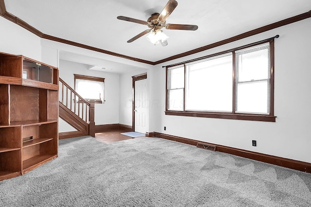512 Henry St, Marion, OH 43302 - carpeted empty room with crown molding, a ceiling fan, baseboards, visible vents, and stairway