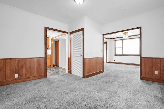 512 Henry St, Marion, OH 43302 - carpeted spare room with ceiling fan, wood walls, ornamental molding, and a wainscoted wall