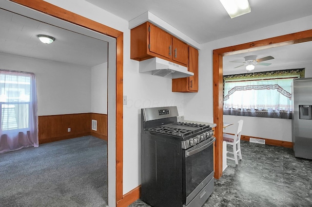 512 Henry St, Marion, OH 43302 - kitchen featuring visible vents, brown cabinets, a wainscoted wall, under cabinet range hood, and stainless steel appliances