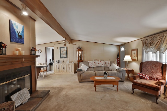 living area featuring a glass covered fireplace, lofted ceiling with beams, and carpet