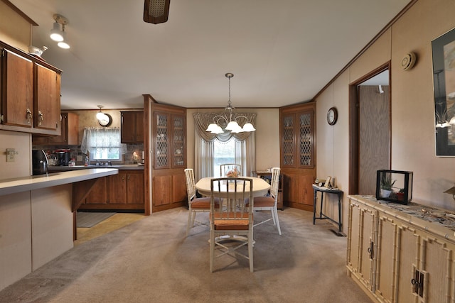 dining area with light colored carpet and a chandelier