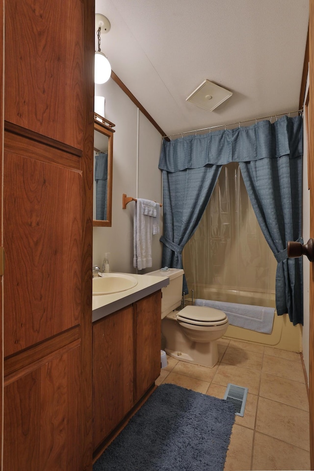 bathroom with visible vents, vaulted ceiling, vanity, tile patterned floors, and toilet