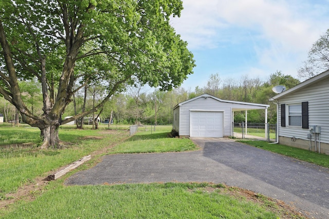 garage with a detached garage, fence, and aphalt driveway