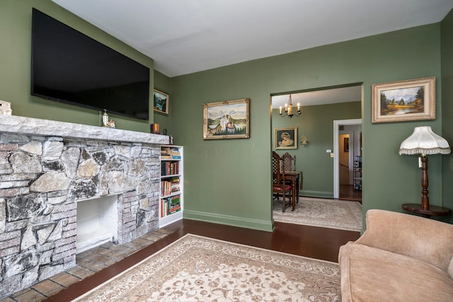 living room featuring baseboards, a chandelier, and wood finished floors
