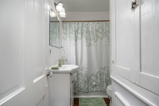 full bath featuring toilet, wood finished floors, and vanity