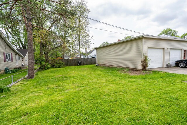 view of yard featuring fence and a garage