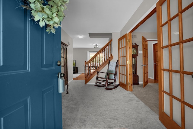 foyer entrance with carpet floors, visible vents, stairway, and french doors