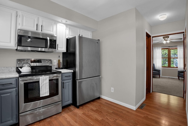 kitchen featuring gray cabinetry, appliances with stainless steel finishes, baseboards, and light countertops