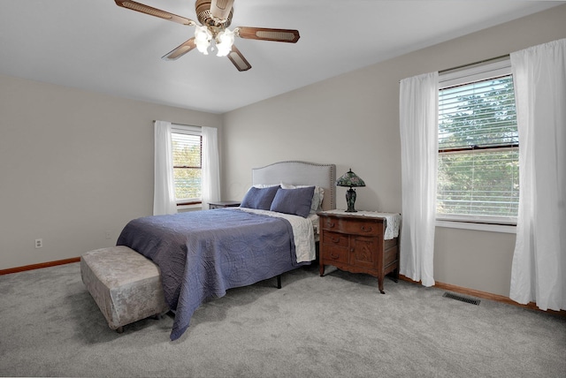 carpeted bedroom featuring baseboards, ceiling fan, and visible vents