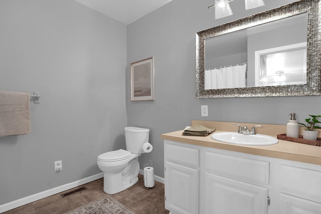 bathroom with baseboards, visible vents, toilet, and vanity