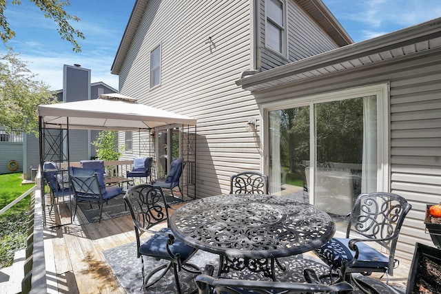 wooden deck with a gazebo and outdoor dining area