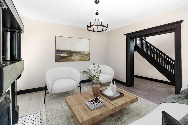 living room with baseboards, a fireplace, wood finished floors, and a chandelier