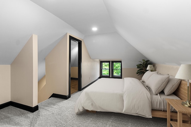 carpeted bedroom with baseboards and vaulted ceiling