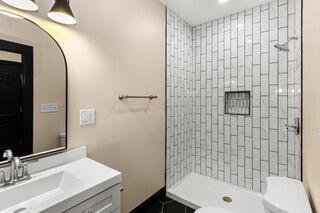 bathroom with toilet, tiled shower, and vanity