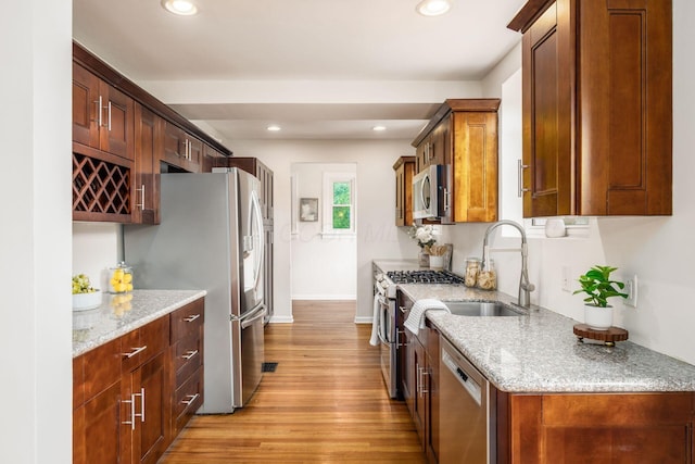 1800 Bryden Rd, Columbus, OH 43205 - kitchen with appliances with stainless steel finishes, a sink, light wood-style flooring, light stone counters, and recessed lighting
