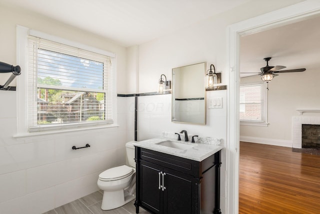 1800 Bryden Rd, Columbus, OH 43205 - bathroom with a fireplace, toilet, wood finished floors, vanity, and a ceiling fan