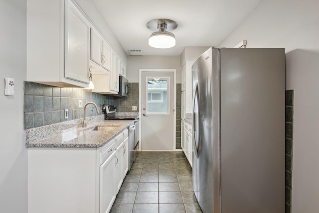kitchen featuring a sink, appliances with stainless steel finishes, backsplash, and white cabinetry