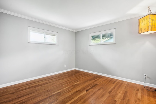 unfurnished room featuring crown molding, baseboards, plenty of natural light, and wood finished floors