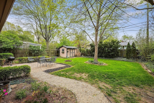 view of yard with a patio, a fenced backyard, a storage shed, and an outdoor structure