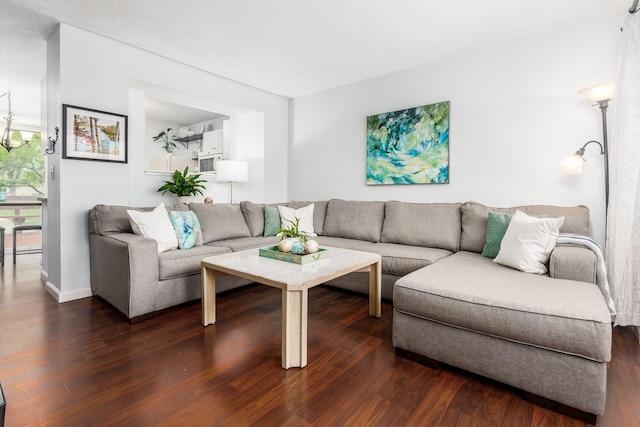 living room with baseboards and dark wood-type flooring