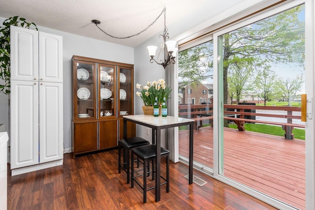 dining area featuring an inviting chandelier, visible vents, and dark wood-type flooring