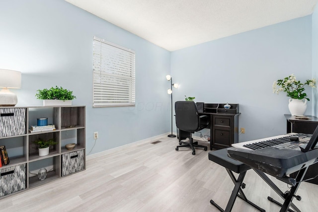 office area with baseboards, visible vents, and wood finished floors