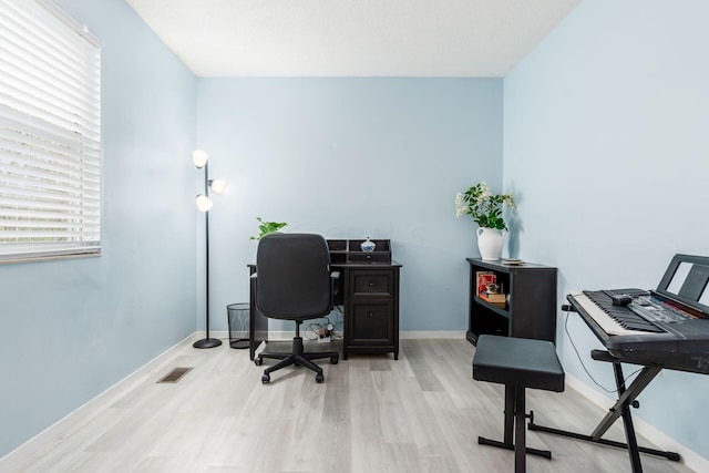 office featuring baseboards, wood finished floors, and visible vents