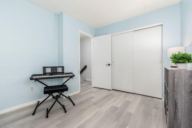 living area featuring baseboards and light wood finished floors