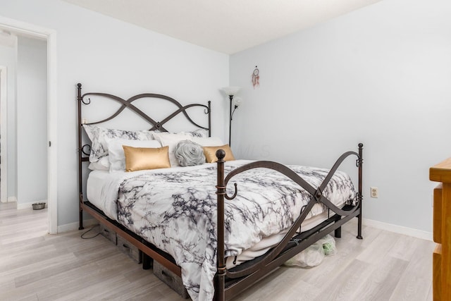 bedroom with light wood-style floors and baseboards