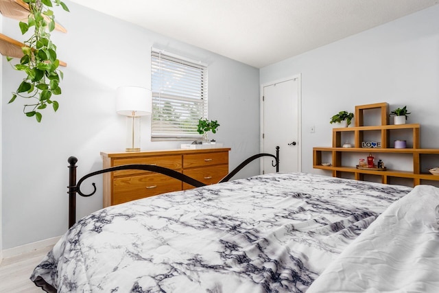 bedroom featuring baseboards and light wood finished floors