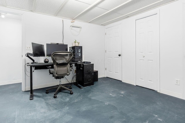 office area featuring baseboards and concrete floors