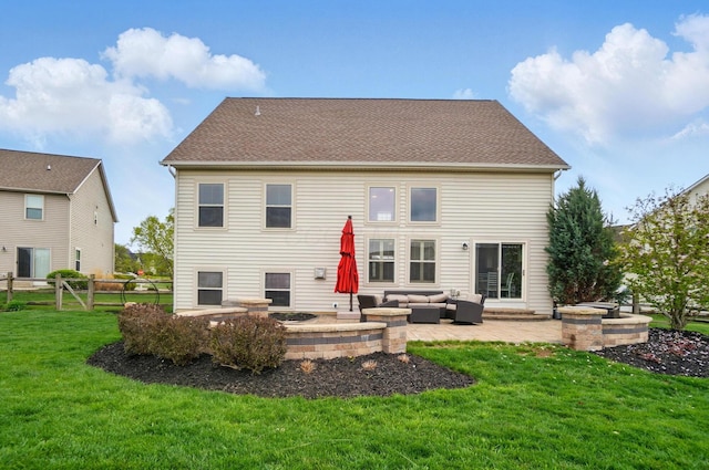 rear view of property featuring a lawn, a patio, fence, and an outdoor living space with a fire pit