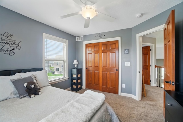 carpeted bedroom featuring a ceiling fan, baseboards, visible vents, and a closet
