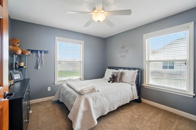 carpeted bedroom with baseboards, ceiling fan, and multiple windows