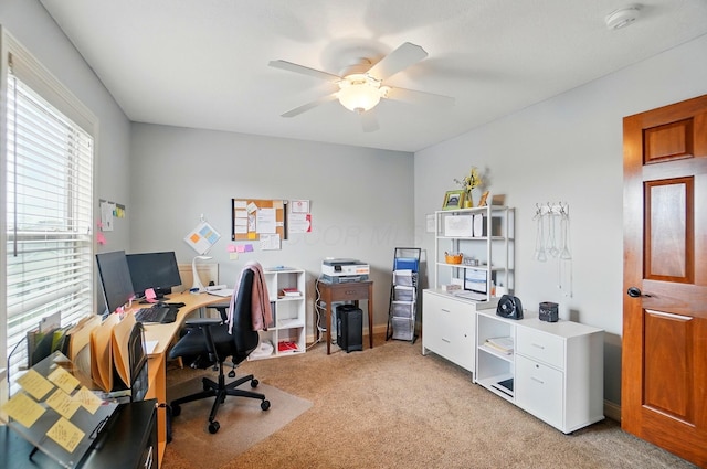 office space featuring light carpet and a ceiling fan