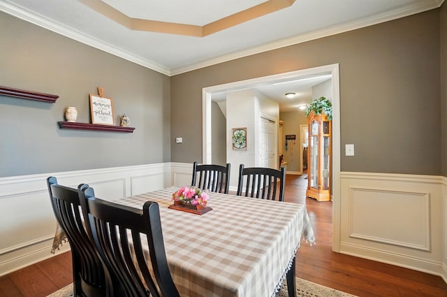 dining area featuring crown molding, wainscoting, and wood finished floors