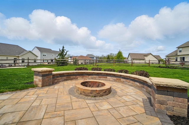 view of patio with a fire pit, fence, and a residential view