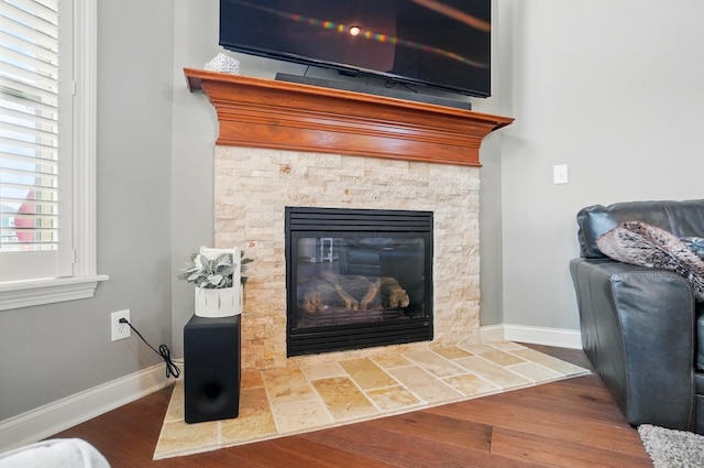 interior details with baseboards, wood finished floors, and a fireplace