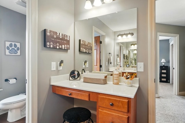 bathroom with vanity, baseboards, and toilet