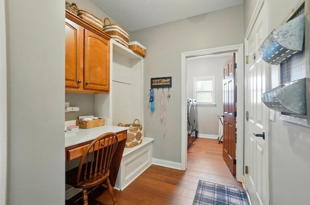 interior space featuring washer / dryer, baseboards, laundry area, and wood finished floors