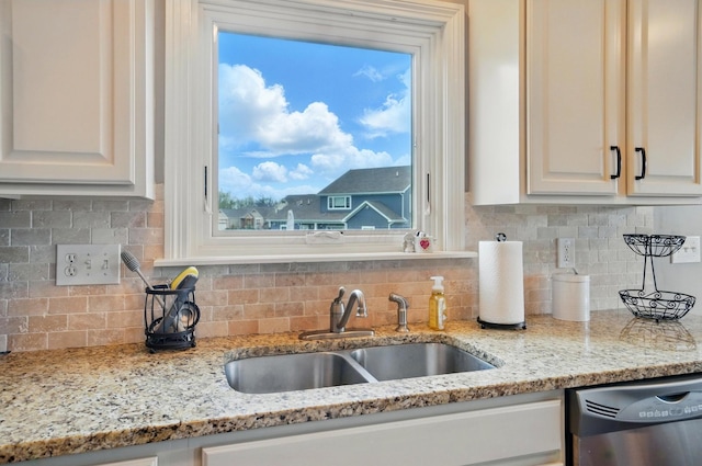kitchen with white cabinetry, decorative backsplash, a sink, and dishwasher