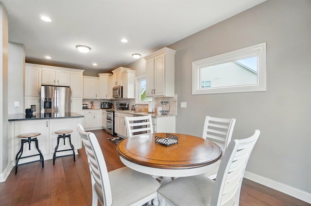 dining space featuring recessed lighting, baseboards, and dark wood-style floors