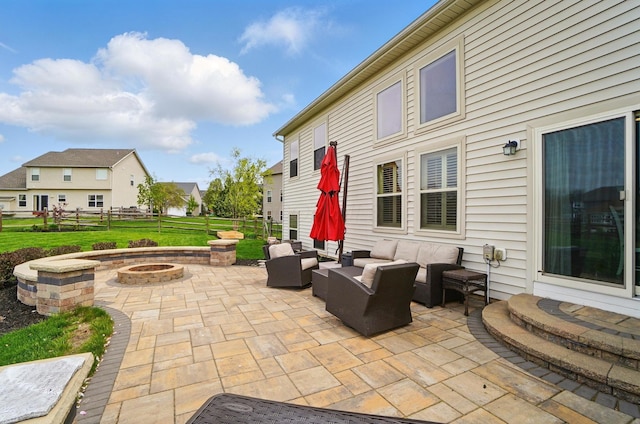 view of patio with an outdoor living space with a fire pit and fence