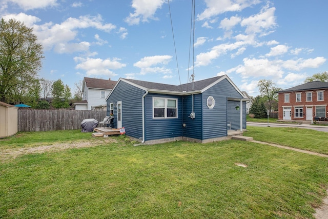 rear view of house featuring a yard and fence