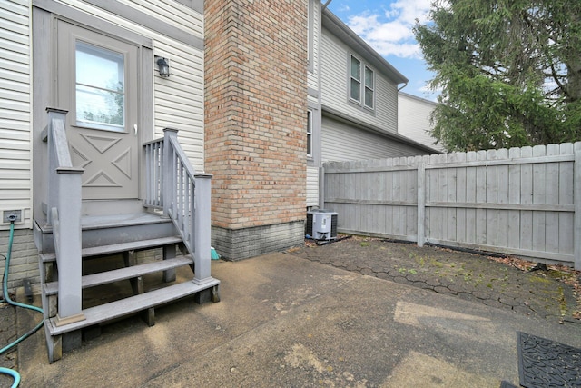 view of side of home featuring central AC unit, a patio area, and fence