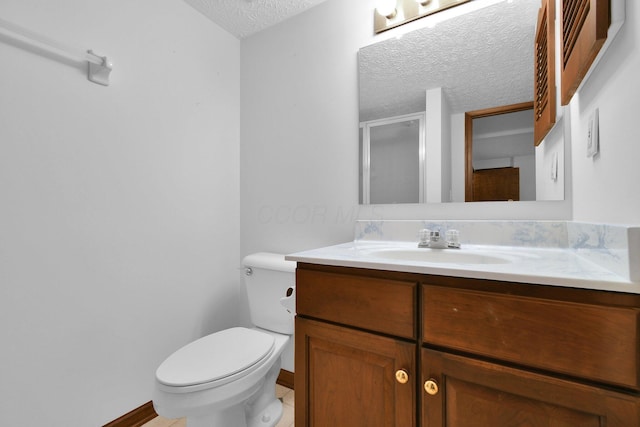 full bathroom with vanity, toilet, a textured ceiling, baseboards, and a shower stall