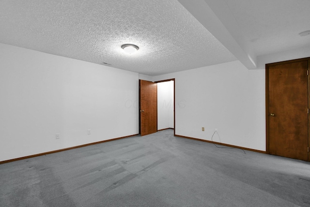 carpeted empty room with baseboards, a textured ceiling, and visible vents