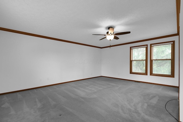 carpeted spare room featuring crown molding, baseboards, and ceiling fan