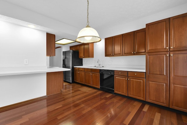 kitchen with a sink, stainless steel fridge with ice dispenser, dishwasher, light countertops, and dark wood-type flooring