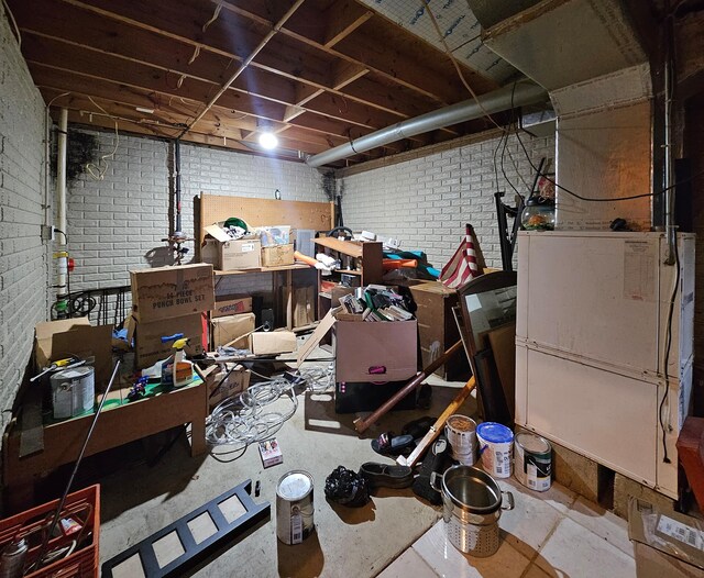 unfinished basement featuring brick wall